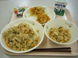 黄飯、かやく、とりの天ぷら、おかかキャベツ、牛乳、豆によろこぶがトレーに並べられた写真