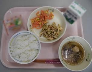 ごはん、牛乳、ゴーヤチャンプルー、もずくのすまし汁、にんじんとツナの和え物(にんじんしりしり風)、沖縄県産シークヮーサータルトがトレーに並べられた写真