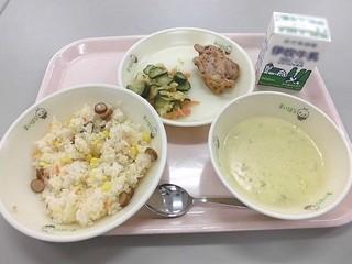 コーンピラフ、牛乳、鶏肉の香草焼き、グリーンポタージュスープ、野菜サラダドレッシング和えがトレーに並べられた写真