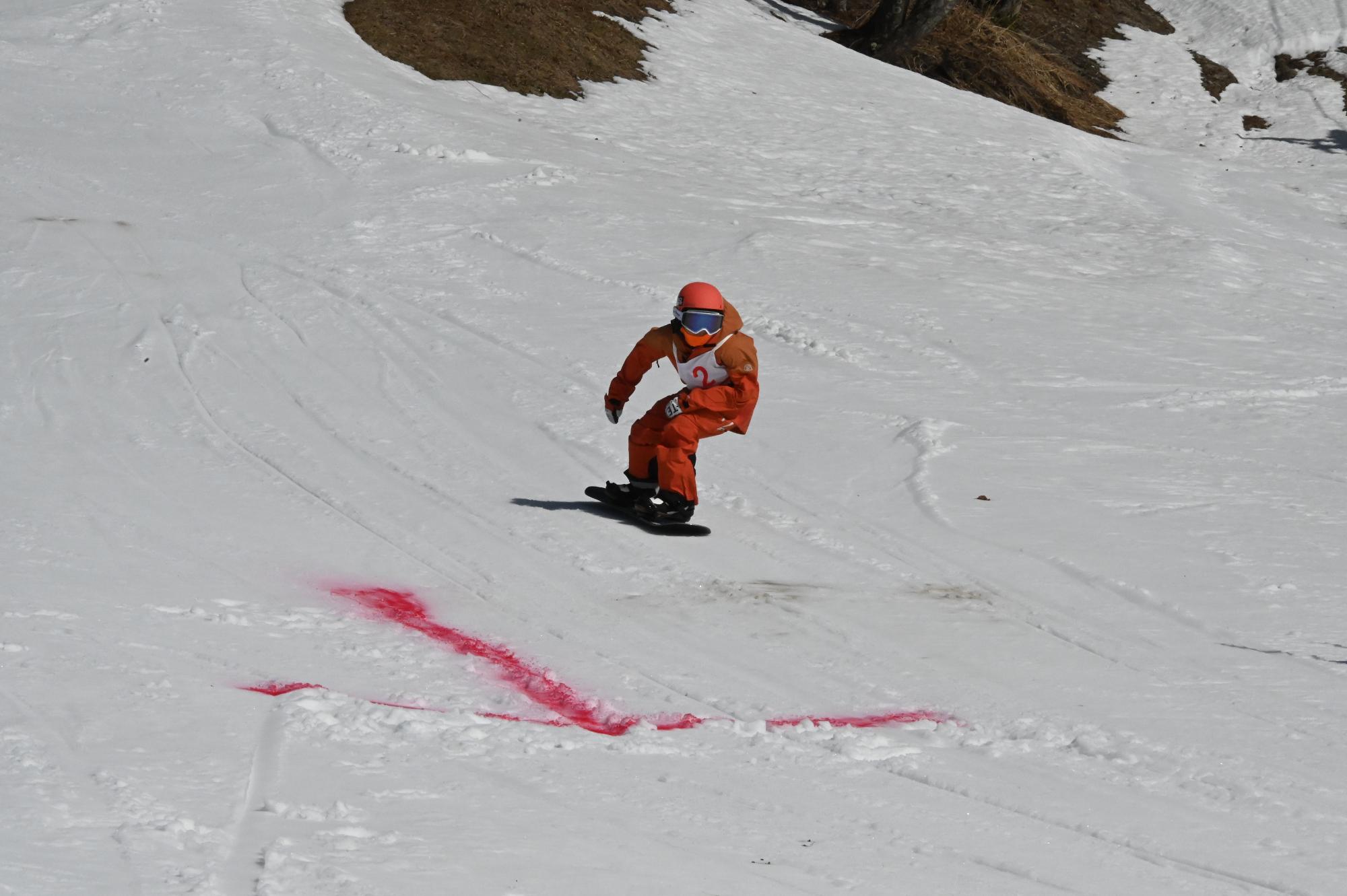 スノーボードで滑走している参加者