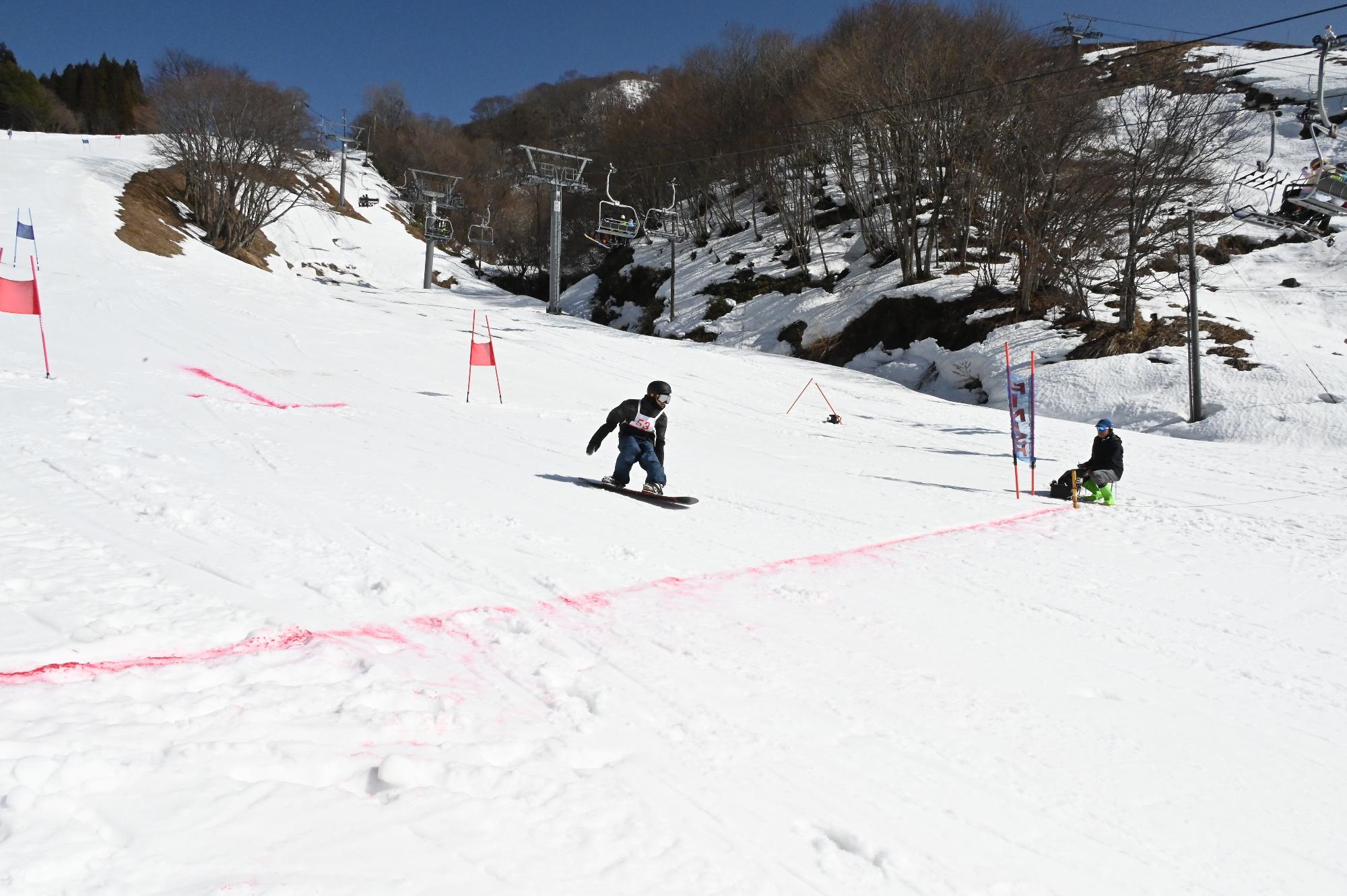 スノーボードで滑っておりゴール間近となっている写真