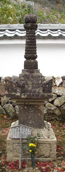 背の高い石で作られ、黄色い花が添えられている、京極道誉の墓の写真