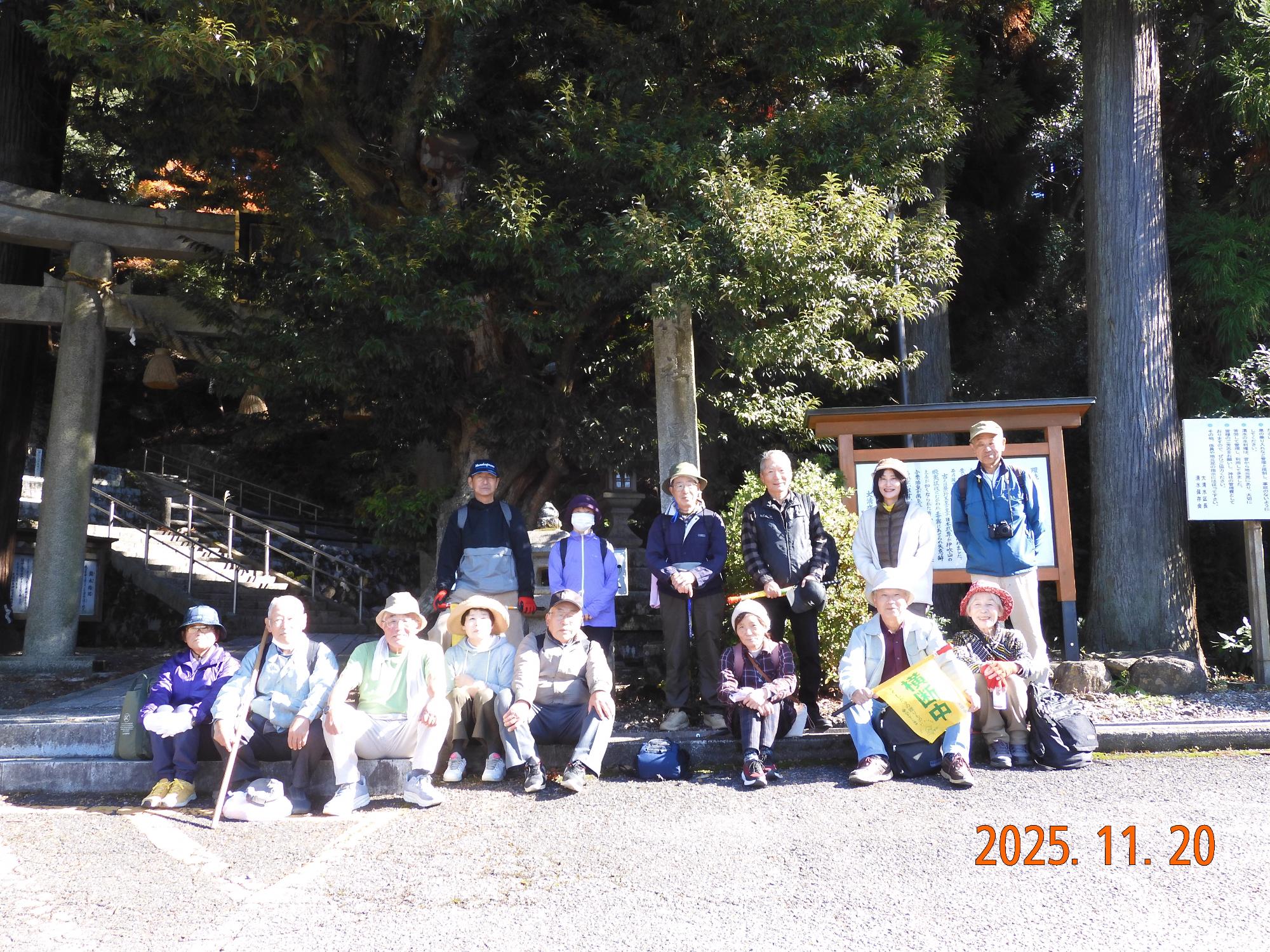 参加者が泉神社の前で記念撮影する写真