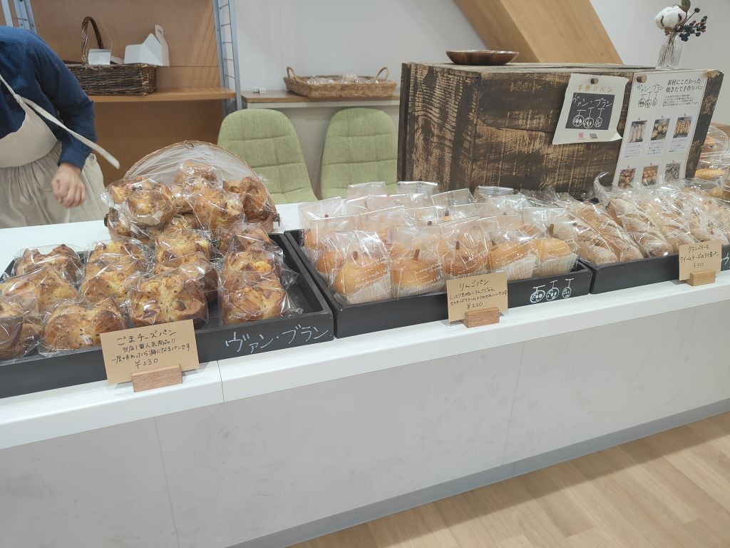 左からごまチーズパン、りんごパン等さまざまなパンが並んでいる写真