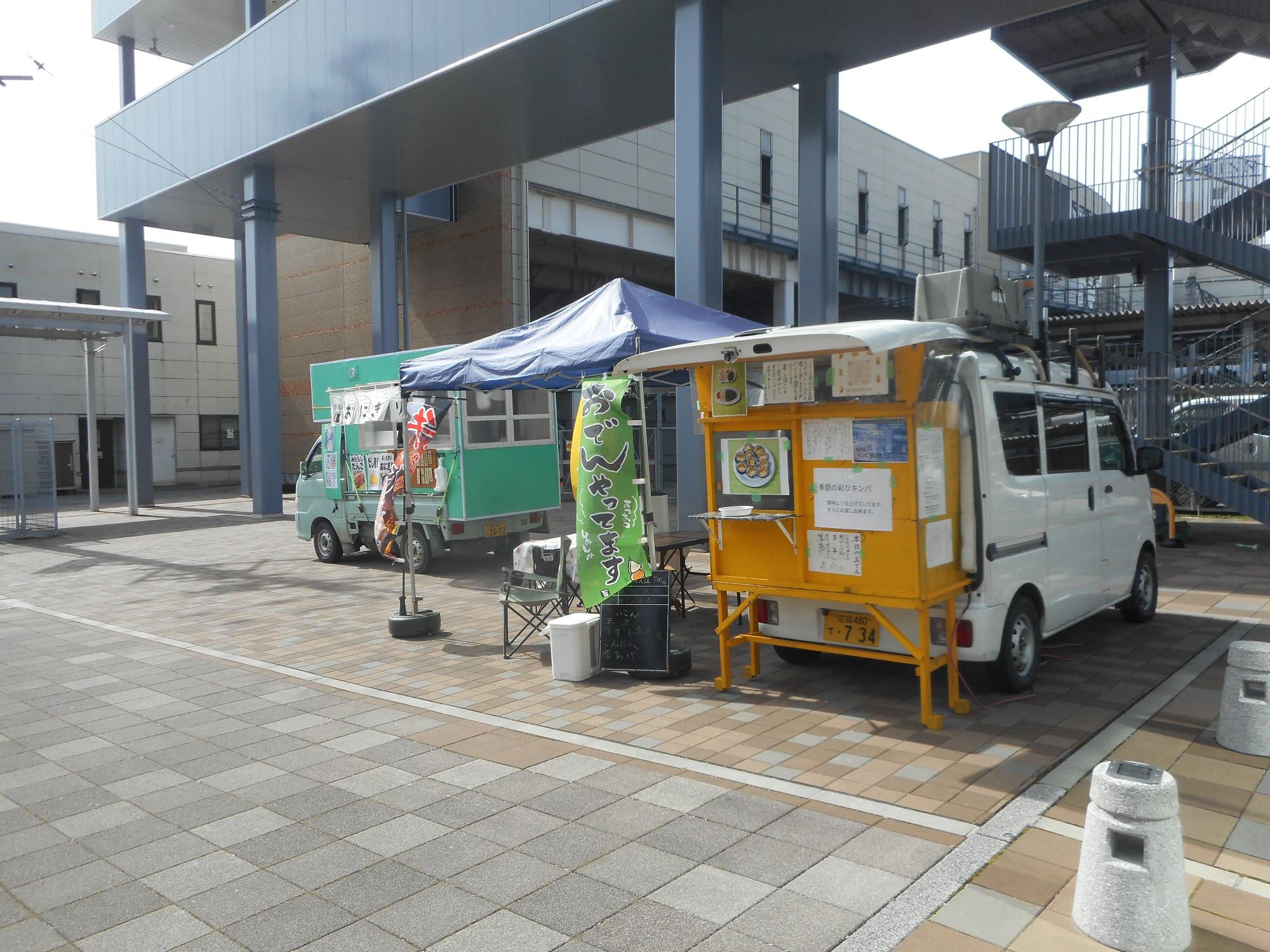 連絡通路下にあるキッチンカー2台の写真。