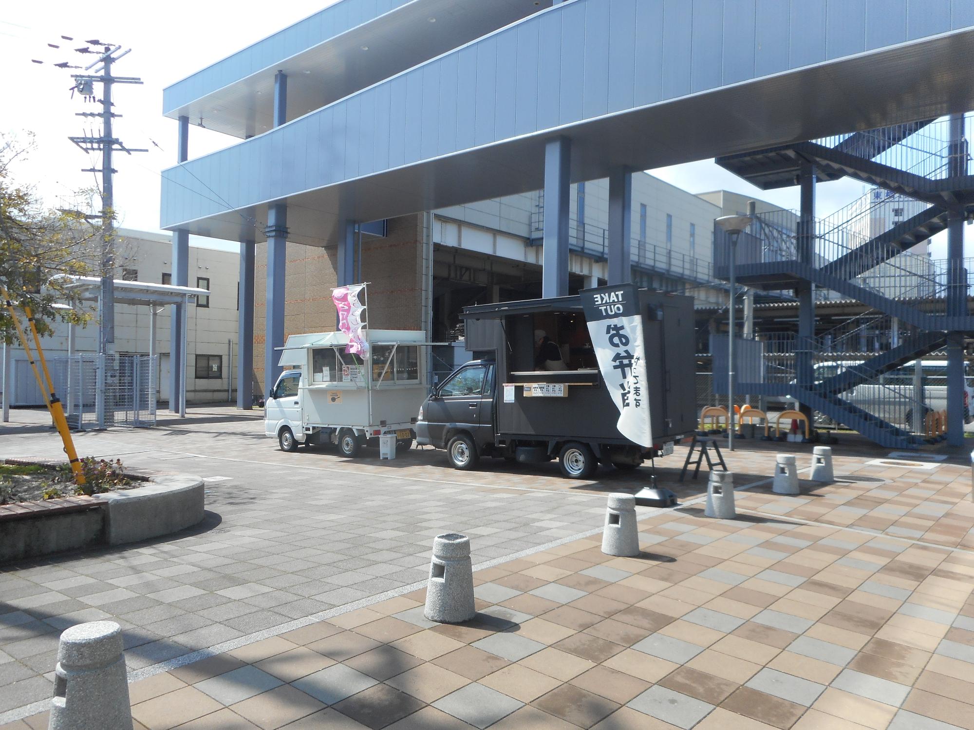 連絡通路下にあるキッチンカー2台の写真。